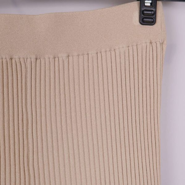 Närbild på ribbstickad midja i beige material