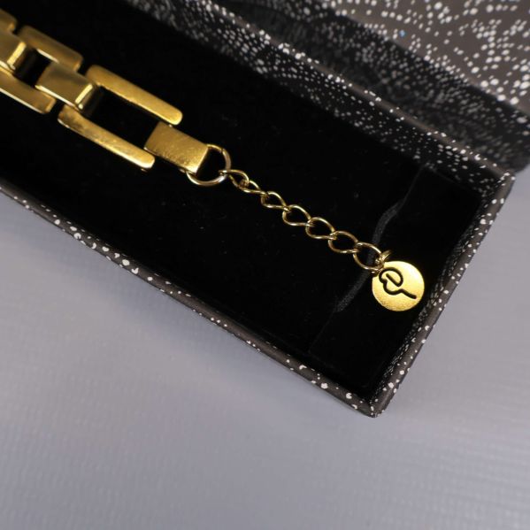 Närbild på armbandets justerbara kedja och Edblad-gravyr