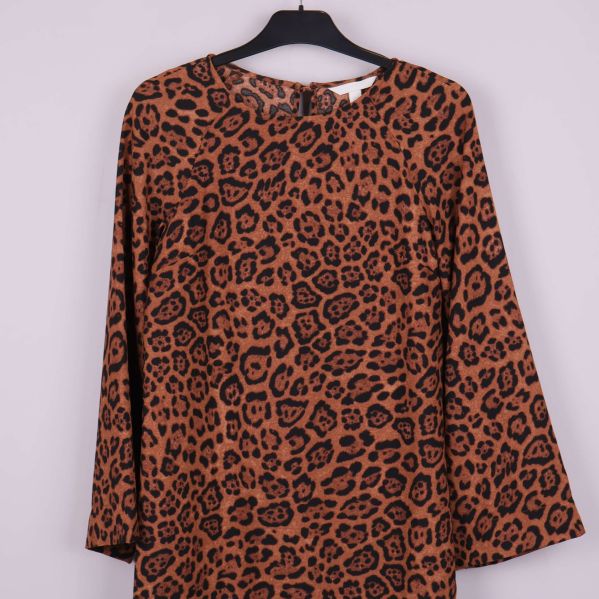 Närbild av leopardmönstrad klänning med rund hals och vida ärmar