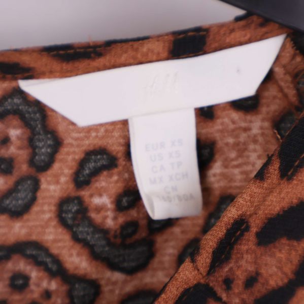 Storleksetikett och H&M logotyp på klänningens insida