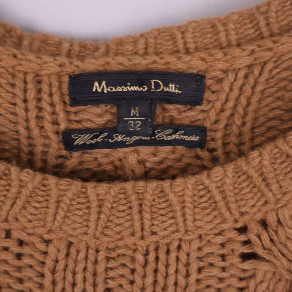 Närbild på Massimo Dutti logotyp på kragskylt