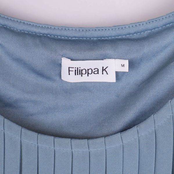 Närbild på Filippa K etikett i nacken på klänning