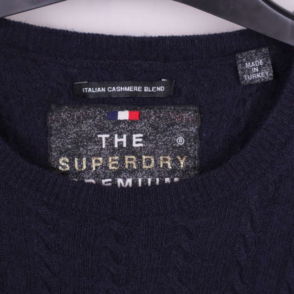 Närbild på halsringning med Superdry Premium etikett och cashmere blend