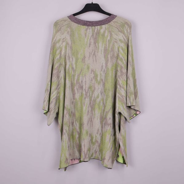 Poncho med grönt och beige mönster bakifrån på galge