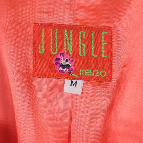 Närbild på JUNGLE KENZO M etikett i orange foder