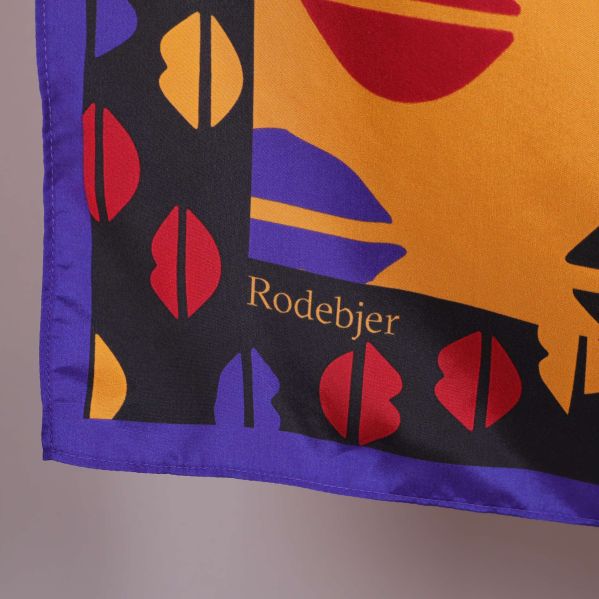 Närbild på hörnet av halsduken med Rodebjer-logga