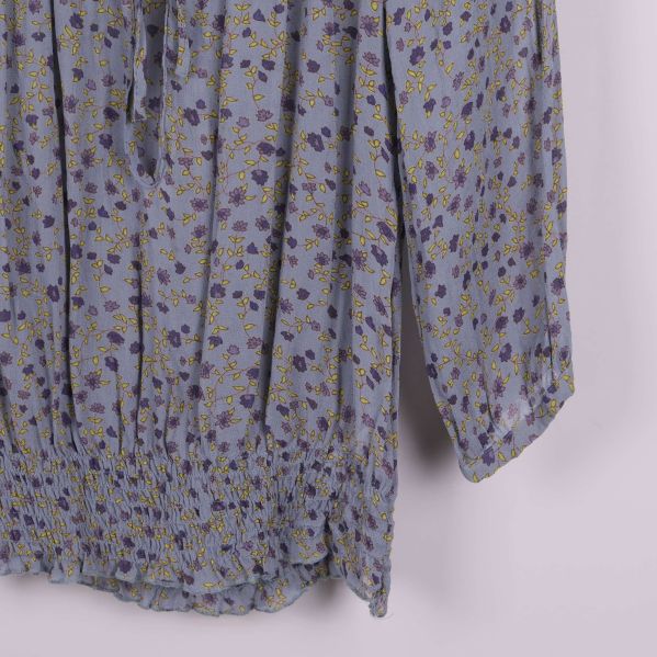 Närbild på smock och blommigt tyg på blus