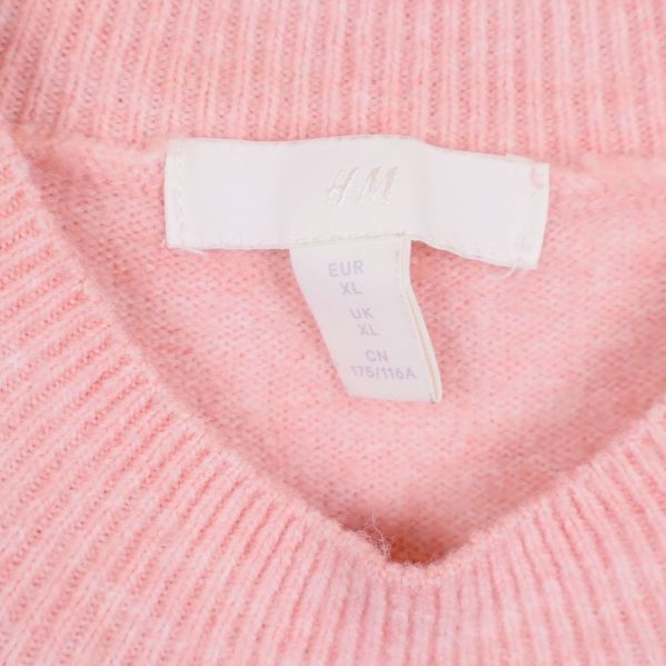 Närbild på etikett i nacken med storlek XL och H&M-logga