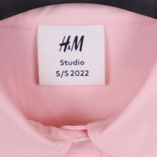 Närbild på nacketikett med texten H&M Studio S/S 2022