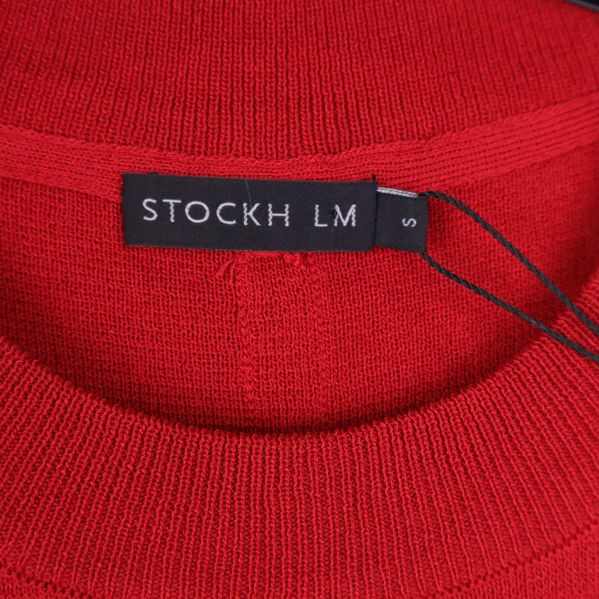 Närbild på etikett med texten STOCKH LM, storlek S