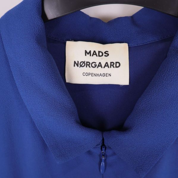 Närbild på Mads Nørgaard Copenhagen-logotyp i halsen på jumpsuiten