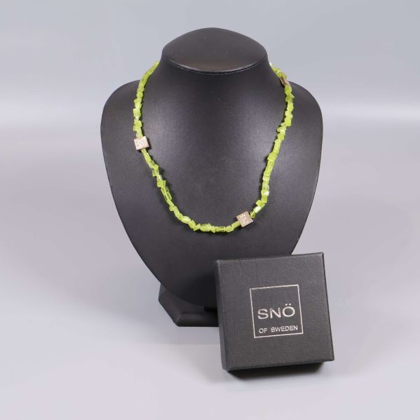 Limegrönt pärlhalsband på svart halsdisplay med SNÖ of Sweden-ask