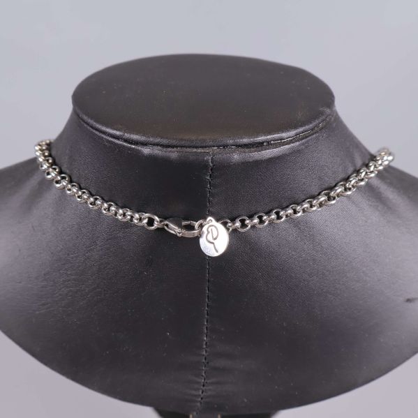 Baksida av halsband med lås och liten silverbricka