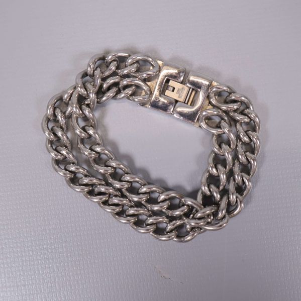 Baksida av grovt silverfärgat kedjearmband