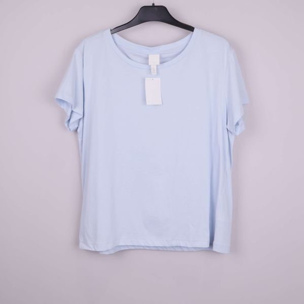 Ljusblå t-shirt upphängd framifrån på galge