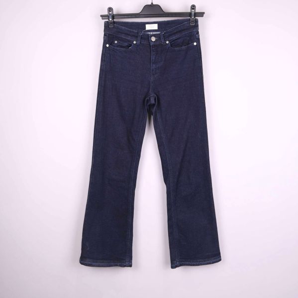 Framsida av mörkblå raka jeans på galge