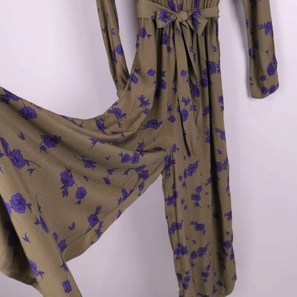 Närbild på vida ben och blommönster på jumpsuit