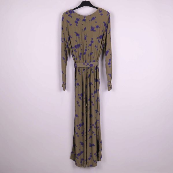Jumpsuit i khakigrönt med lila blommönster bakifrån på galge
