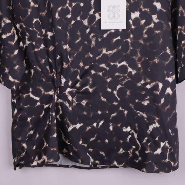 Närbild på blusens nederdel och tygets fall