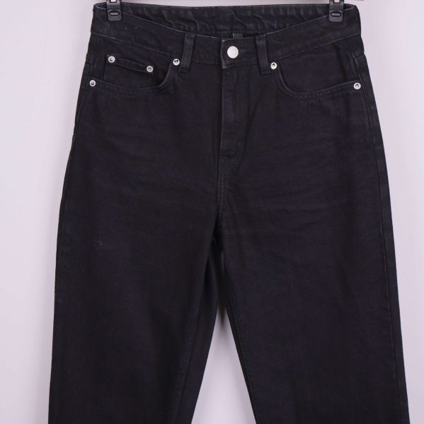 Närbild på midja och fickor framtill på svarta jeans