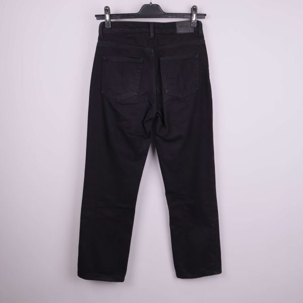Baksidan av svarta jeans med fickor och etikett