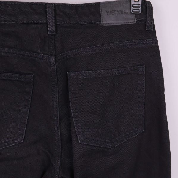 Närbild på bakfickor och logga på svarta jeans