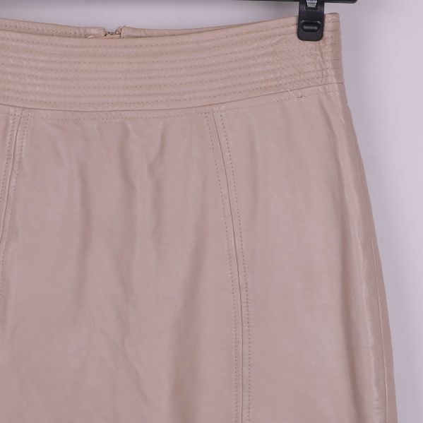 Närbild på midja och struktur i beige läder
