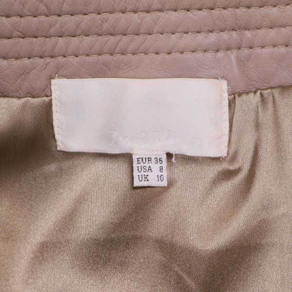 Storleksetikett med EUR 36 i beige kjol