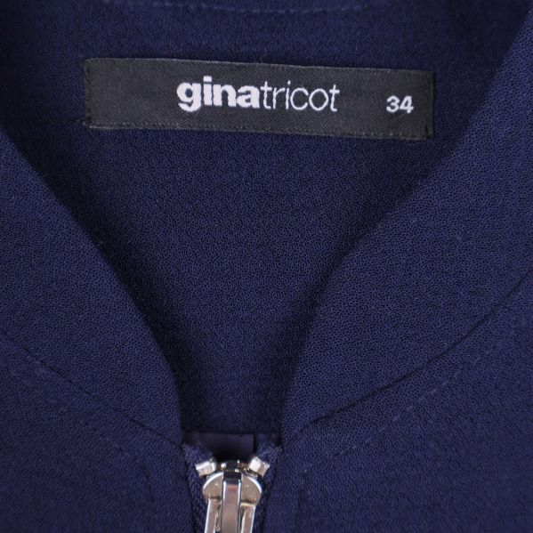 Närbild på gina tricot-märke och storlek 34