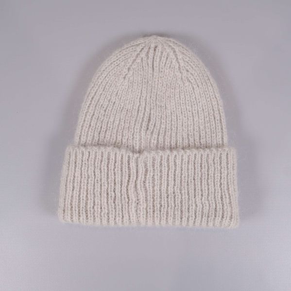 Beige stickad mössa sedd bakifrån med bred kant