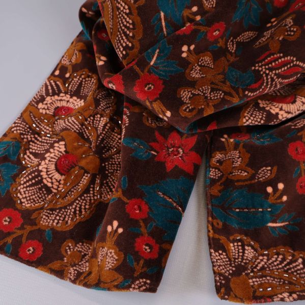 Närbild på blommönstrad textil i brunt och rött