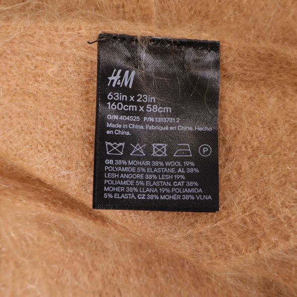 Materialetikett på beige sjal med materialinfo