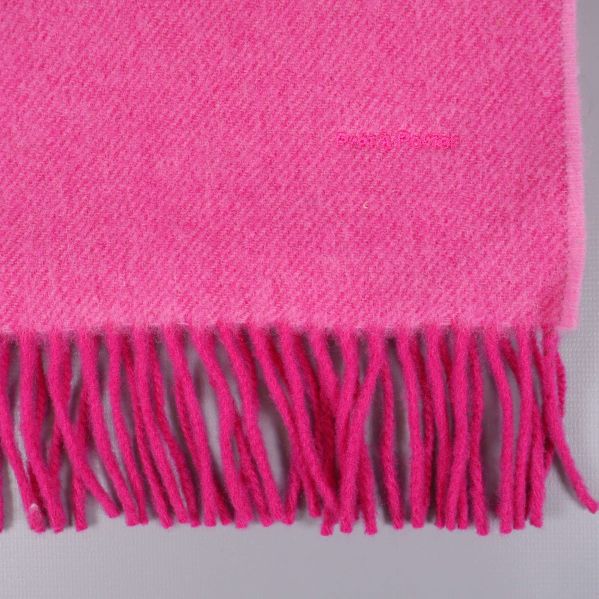 Närbild på rosa halsdukens nedre kant med fransar