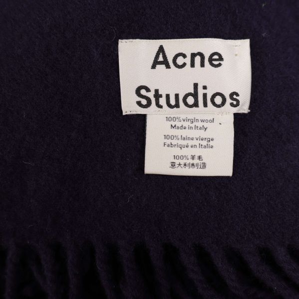 Etikett Acne Studios och materialinfo i halsdukens hörn