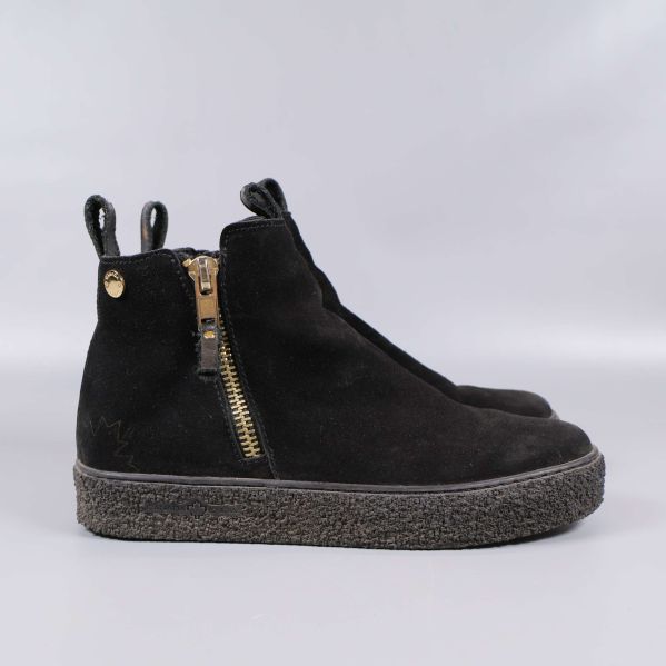 Svart boots från sidan med guldig dragkedja