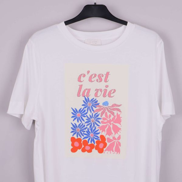 Närbild på blommigt tryck och text c'est la vie