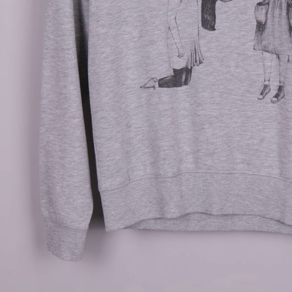 Närbild på ärm och nederkant av grå sweatshirt