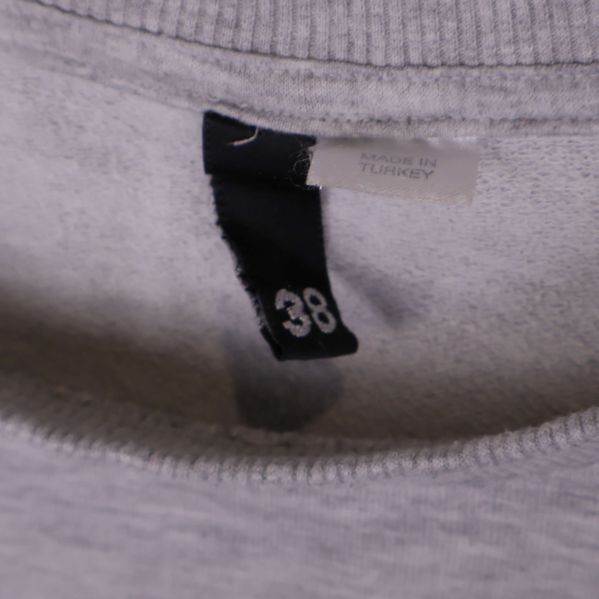 Storleksetikett 38 i halsen på sweatshirten