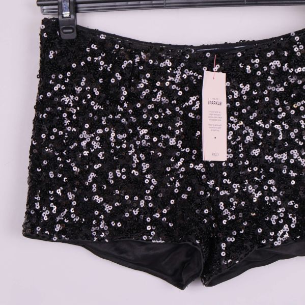 Detaljbild på paljettshorts med hängande prislapp