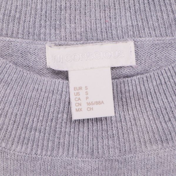 Närbild på H&M Conscious etikett och storlekslapp S