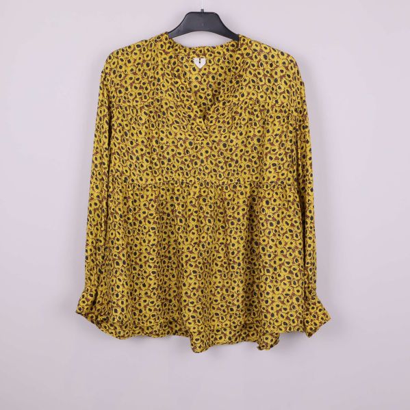 Blommig blus i gult med svarta detaljer, framifrån