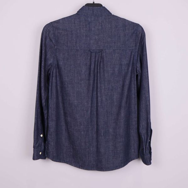 Baksida av denimskjorta med enkel söm och veck