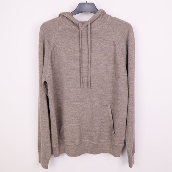 Gråbeige hoodie med huva och ficka hängande på galge