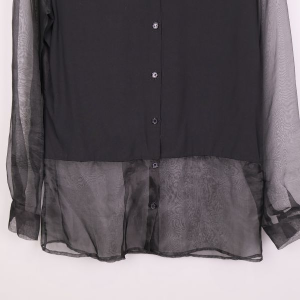 Nederdel av svart blus med transparent tyg