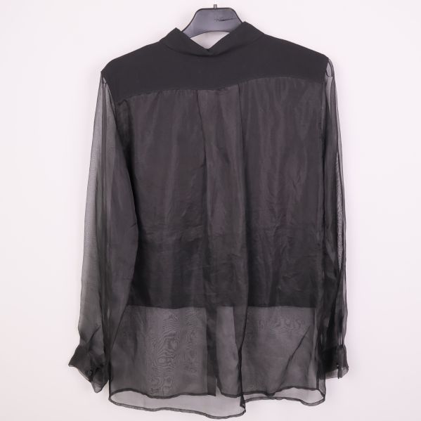 Svart blus med transparenta partier visad bakifrån