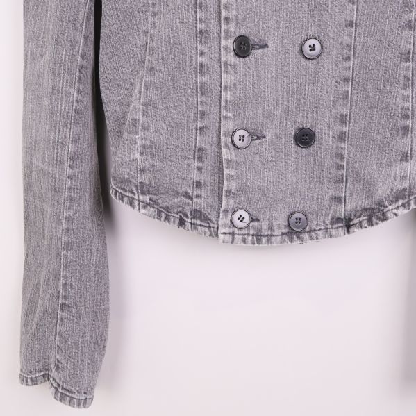 Närbild på knappdetaljer och fåll på denimjacka