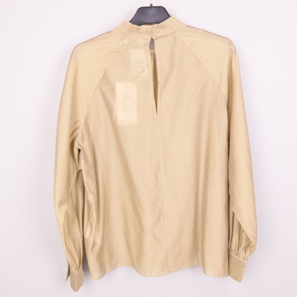 Baksidan av beige blus med knappslå