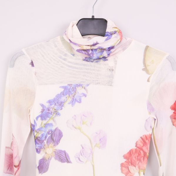 Närbild på polokrage och blommigt mönster upptill