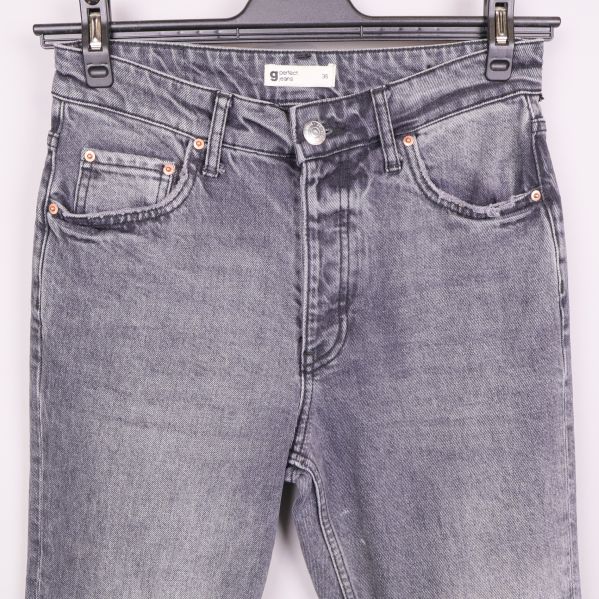Detalj på fickor och midja framtill på grå jeans