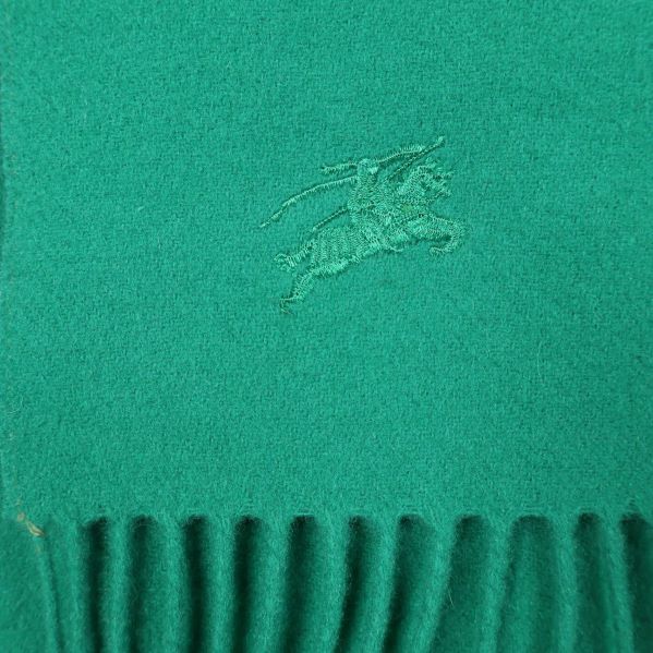 Broderad logotyp på grön halsduk nära franskant